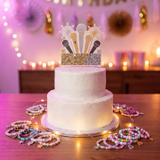 Sparkly concert themed birthday cake with musical edible topper, friendship bracelets and fairy lights